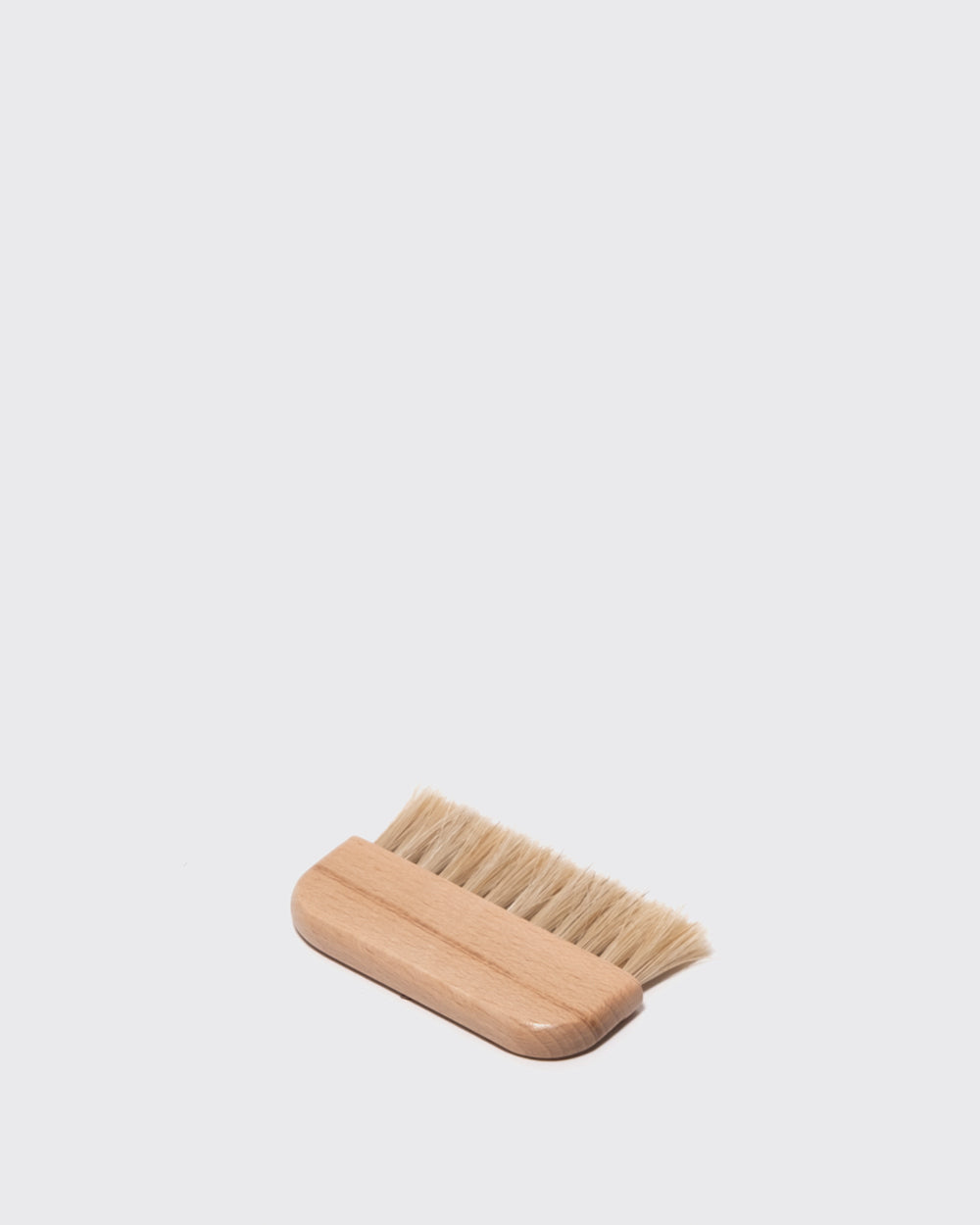 Mini klædebørste liggende på skrå
